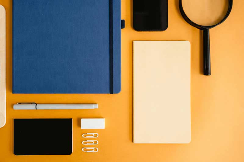Desk with custom office supplies including notebooks and pens.